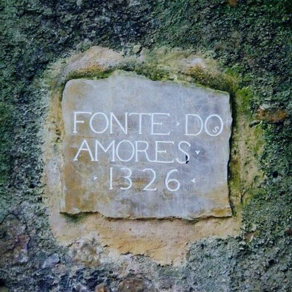 Pedra branca com o texto inscrito "FONTE DO AMORES" e o ano "1326"