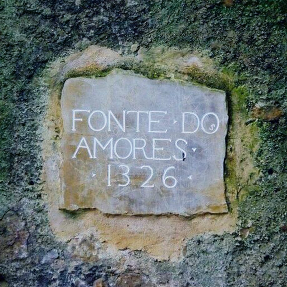 Pedra clara com o texto inscrito "FONTE DO AMORES" e o ano "1326"